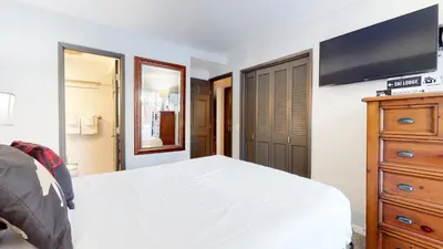 a bedroom with a bed and a dresser with a tv at Mammoth Estates Condo - Free Parking & Pet Friendly in Mammoth Lakes