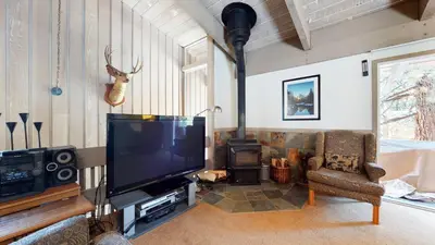 a living room with a flat screen tv and a fireplace at Mammoth Estates Condo - Near Village at Mammoth & Pet Friendly in Mammoth Lakes