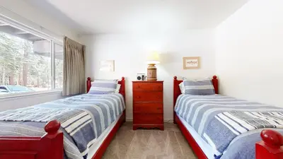 two beds in a room with a window at Mammoth Estates Condo - Near Village at Mammoth & Pet Friendly in Mammoth Lakes