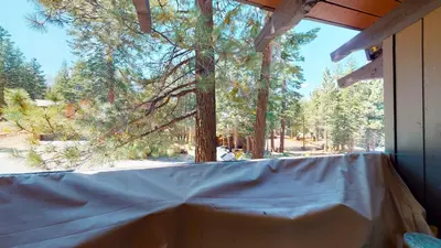 a screened in porch with a large window with trees at Mammoth Estates Condo - Near Village at Mammoth & Pet Friendly in Mammoth Lakes