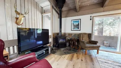 a living room with a flat screen tv and a fireplace at Mammoth Estates Condo - Near Village at Mammoth & Pet Friendly in Mammoth Lakes