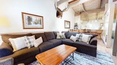 a living room with a couch and a table at Mammoth Estates Condo - Near Village at Mammoth & Pet Friendly in Mammoth Lakes