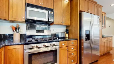 a kitchen with a stove and a stainless steel refrigerator at Grayfox 2 Pet-Friendly, 5-Star with Private Hot Tub, 2 Car Garage and Prime Location condo in Mammoth Lakes