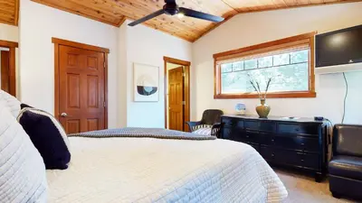 a bedroom with a bed and a flat screen tv at Grayfox 2 Pet-Friendly, 5-Star with Private Hot Tub, 2 Car Garage and Prime Location condo in Mammoth Lakes