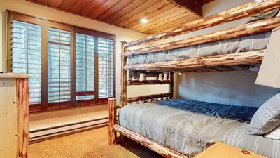 a bedroom with two bunk beds in a room with windows at Val DIsere 32 Pet-Friendly, Walk To The Village, Private Washer Dryer, Spacious Floorplan condo in Mammoth Lakes