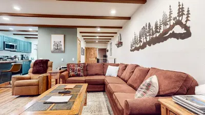 a living room with a couch and a table at Val DIsere 32 Pet-Friendly, Walk To The Village, Private Washer Dryer, Spacious Floorplan condo in Mammoth Lakes