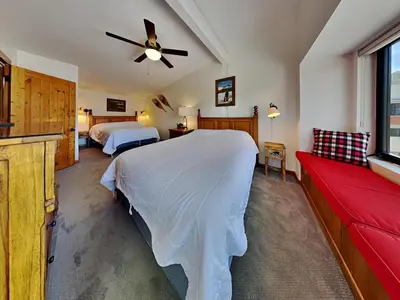 a bedroom with two beds and a red couch at Summer Fun - SLOPESIDE 4BR 3BA with 3 Spas, Pool and Sauna - Perfect for Family and Friend Getaways All Year Round 1849 Condos 693 condo in Mammoth Lakes