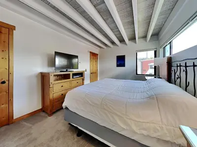 a bedroom with a bed and a flat screen tv at Summer Fun - SLOPESIDE 4BR 3BA with 3 Spas, Pool and Sauna - Perfect for Family and Friend Getaways All Year Round 1849 Condos 693 condo in Mammoth Lakes