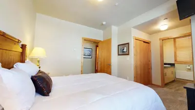 a bedroom with a large white bed and a bathroom at Solstice 11 Amazing Location on Golf Course, Heated Garage, Private Washer Dryer condo in Mammoth Lakes