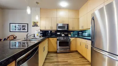 a kitchen with wooden cabinets and a stainless steel refrigerator at Solstice 11 Amazing Location on Golf Course, Heated Garage, Private Washer Dryer condo in Mammoth Lakes