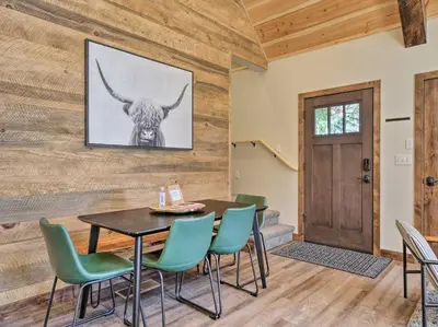 a dining room with a table and chairs and a bull painting at Woodsy Retreat Modern Mi-Wuk Village Cabin! in Mi-Wuk Village