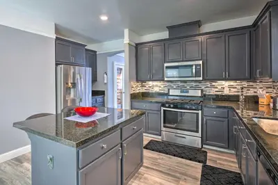 a kitchen with black cabinets and a counter top at Modern Sacramento House about 12 Mi to Downtown! in Sacramento