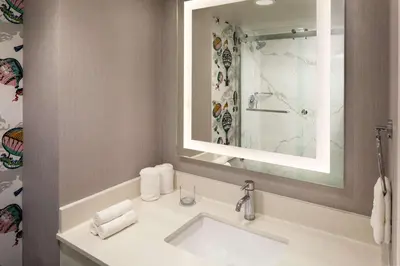a bathroom with a sink and a mirror at Whitney Peak Hotel Reno, Tapestry Collection by Hilton in Reno