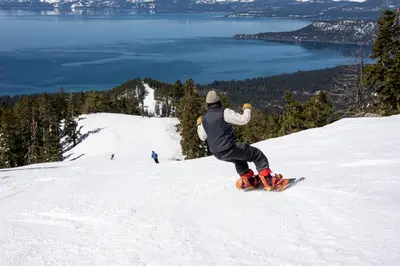a man riding a snowboard down a snow covered slope at The Incline Lodge in Incline Village