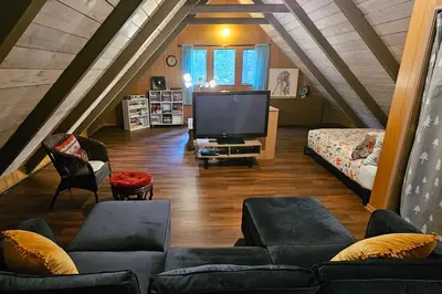 a living room with a couch and a tv at Hidden Haven in Arnold