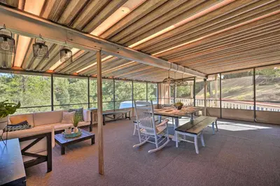 a large room with a table and chairs and windows at Jackson Escape with Hot Tub and Mtn Views! in Jackson