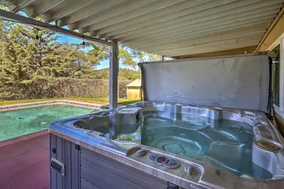a hot tub in a backyard with a swimming pool at Jackson Escape with Hot Tub and Mtn Views! in Jackson
