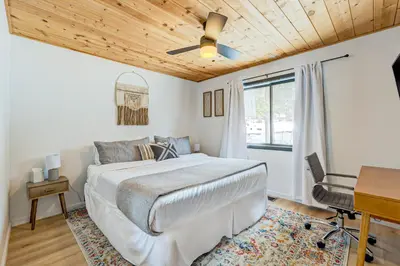 a bedroom with a bed and a desk and a window at Bolzano's Getaway in Truckee