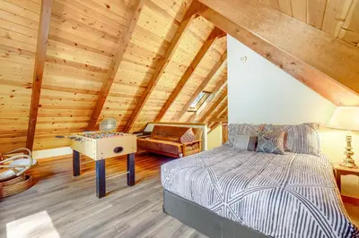 a bedroom with a bed and a table in a attic at Tranquility in the Woods in Arnold