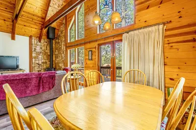 a dining room with a wooden table and chairs at Tranquility in the Woods in Arnold