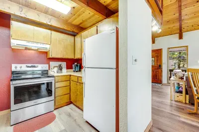 a white refrigerator in a kitchen with wooden cabinets at Tranquility in the Woods in Arnold