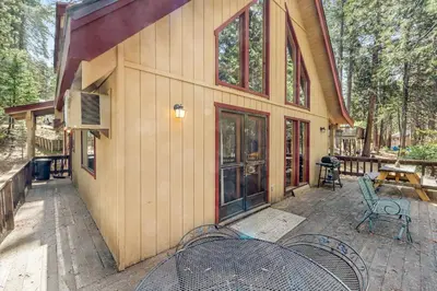 a house with a table and chairs in front of it at Tranquility in the Woods in Arnold