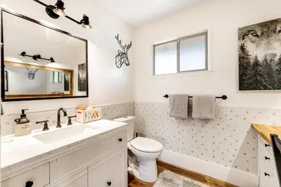 a bathroom with a sink and a toilet and a mirror at Paws Place in Arnold