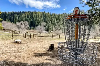 a frisbee golf basket in a field with a fence at Paws Place in Arnold
