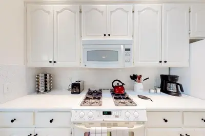 a white kitchen with a stove and a microwave at The 19th Hole in Groveland