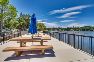 a blue umbrella and benches next to the water at The 19th Hole in Groveland