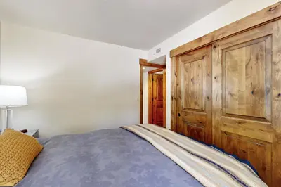 a bedroom with a bed and a wooden cabinet at Lakeshore Townhome 20 in Incline Village