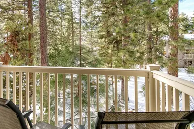 a balcony with a table and a chair and trees at Lakeshore Townhome 20 in Incline Village