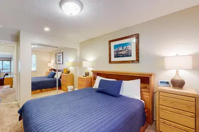 a bedroom with a blue bed and a mirror at Lake Village Townhouse B in Zephyr Cove