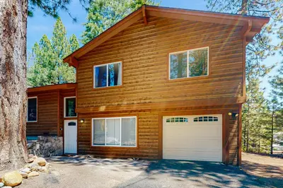 a house with two garage doors and a tree at Allen Way Escape in Incline Village