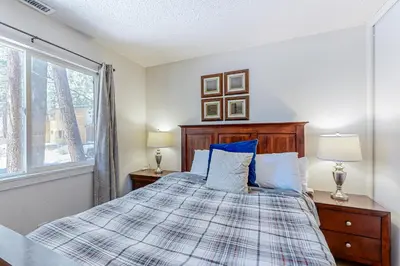 a bedroom with a bed with blue pillows and a window at Allen Way Escape in Incline Village