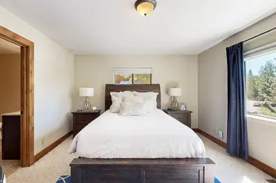 a bedroom with a bed with white sheets and a window at Tyner Dreams in Incline Village