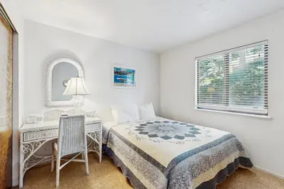 a bedroom with a bed and a desk and a window at Katherine Court Townhouse in Stateline