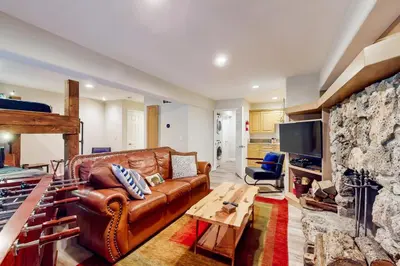 a living room with a leather couch and a stone fireplace at Boothill Adventures in Incline Village