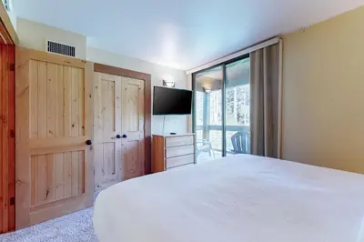 a bedroom with a large white bed and a television at Aspen Grove Condo in Truckee