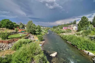 a river with rocks and houses in a town at Conifer Donner in Truckee