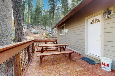 a porch with a picnic table and a white door at Conifer Donner in Truckee