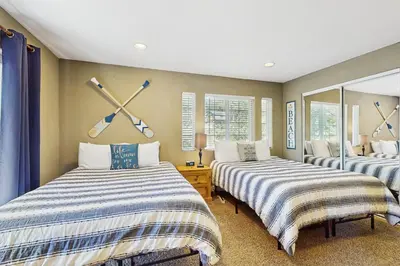 a bedroom with two beds and a clock on the wall at Skyline Manor in South Lake Tahoe