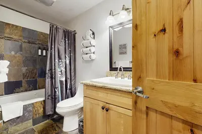 a bathroom with a toilet and a sink and a mirror at Skyline Manor in South Lake Tahoe