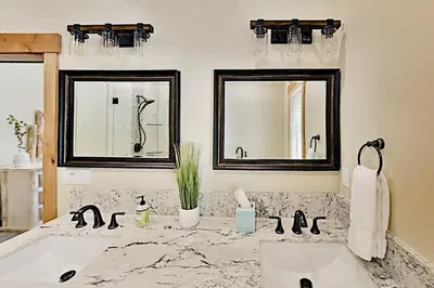 a bathroom with two sinks and two mirrors at Saponi Escape in South Lake Tahoe