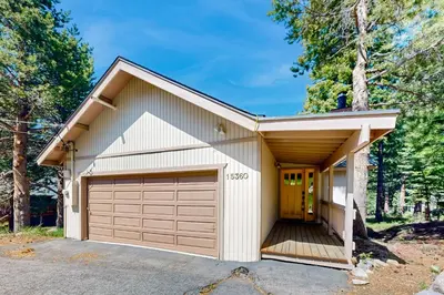 a house with a garage in a forest at Wolfgang Dreams in Truckee
