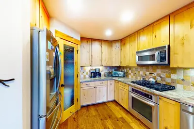 a kitchen with wooden cabinets and stainless steel appliances at St Bernard Oasis in Truckee