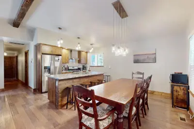 a large kitchen with a wooden table and chairs at Homewood Cabin Among the Pines in Homewood