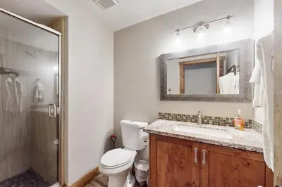 a bathroom with a toilet and a sink and a shower at Homewood Cabin Among the Pines in Homewood