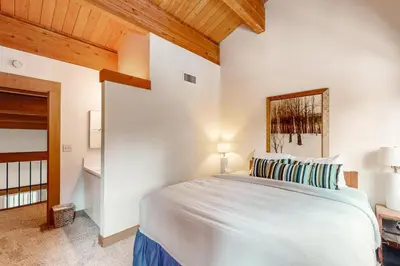a bedroom with a white bed and a wooden ceiling at Aspen Grove Escape in Truckee