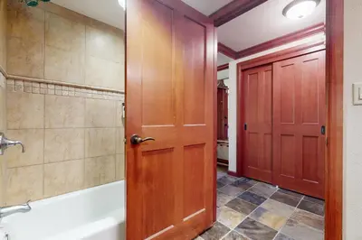 a bathroom with a wooden door and a bath tub at Resort at Squaw Creek's 806 & 808 in Olympic Valley